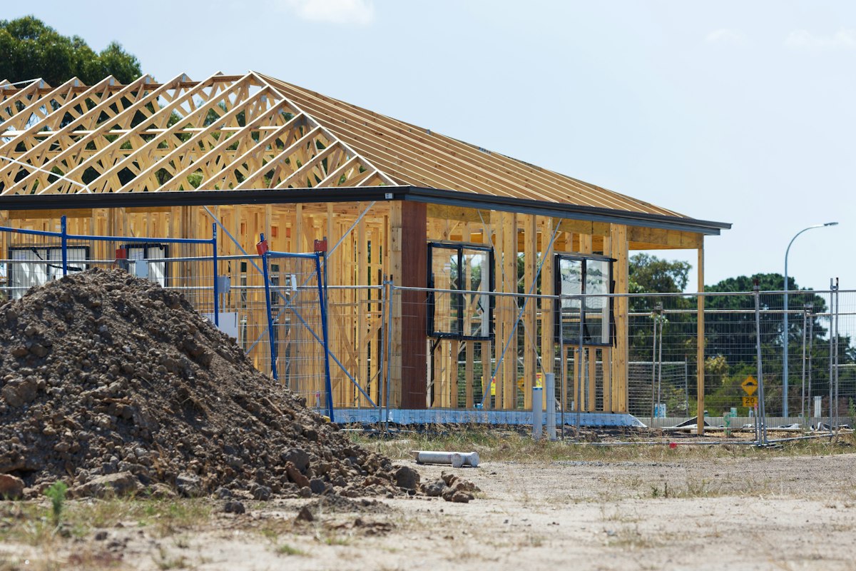 Single-story home under construction: Front perspective · wall framing and roof trusses